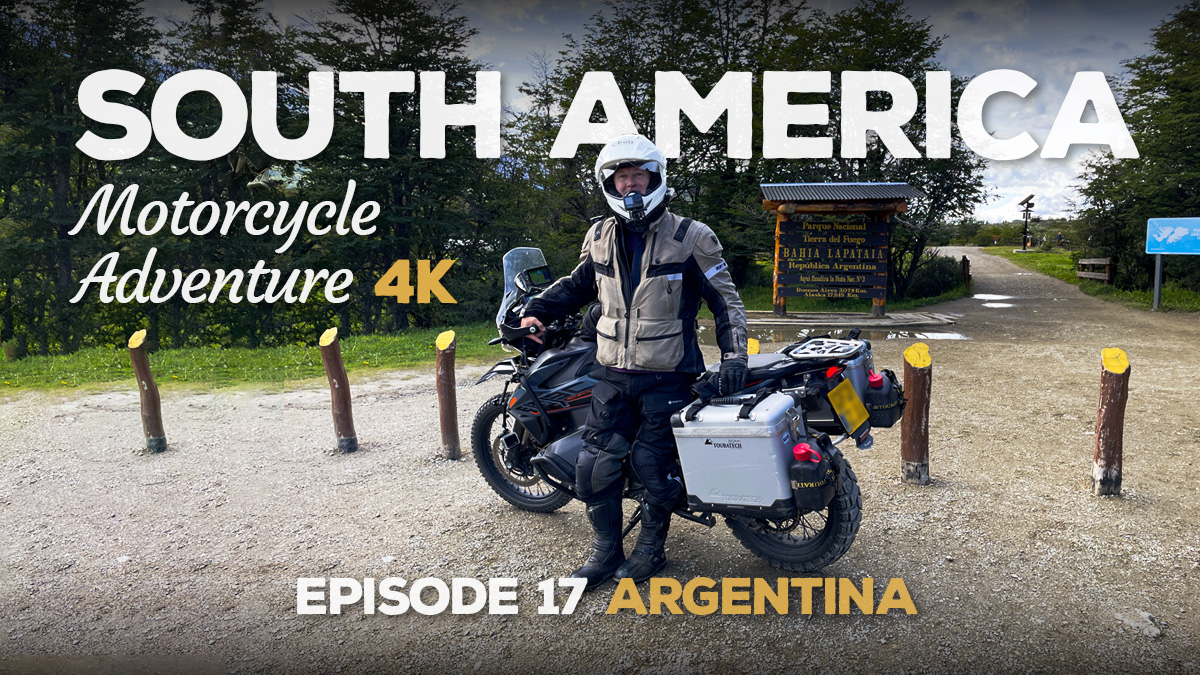 A picture of a motorcyclist parked in front of the end of the Pan-America Highway sign in Tierra del Fuego, Argentina