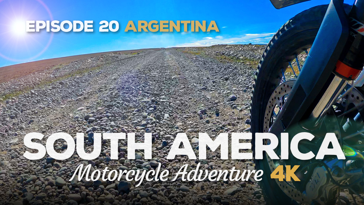 A low angle shot of a motorcycle wheel travelling down a gravel road