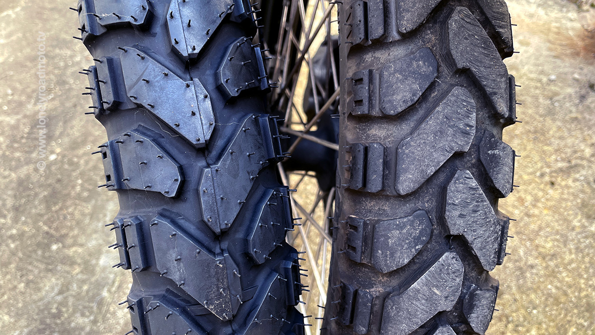 Close up of a worn Mitas e07+ front tyre next to a new one