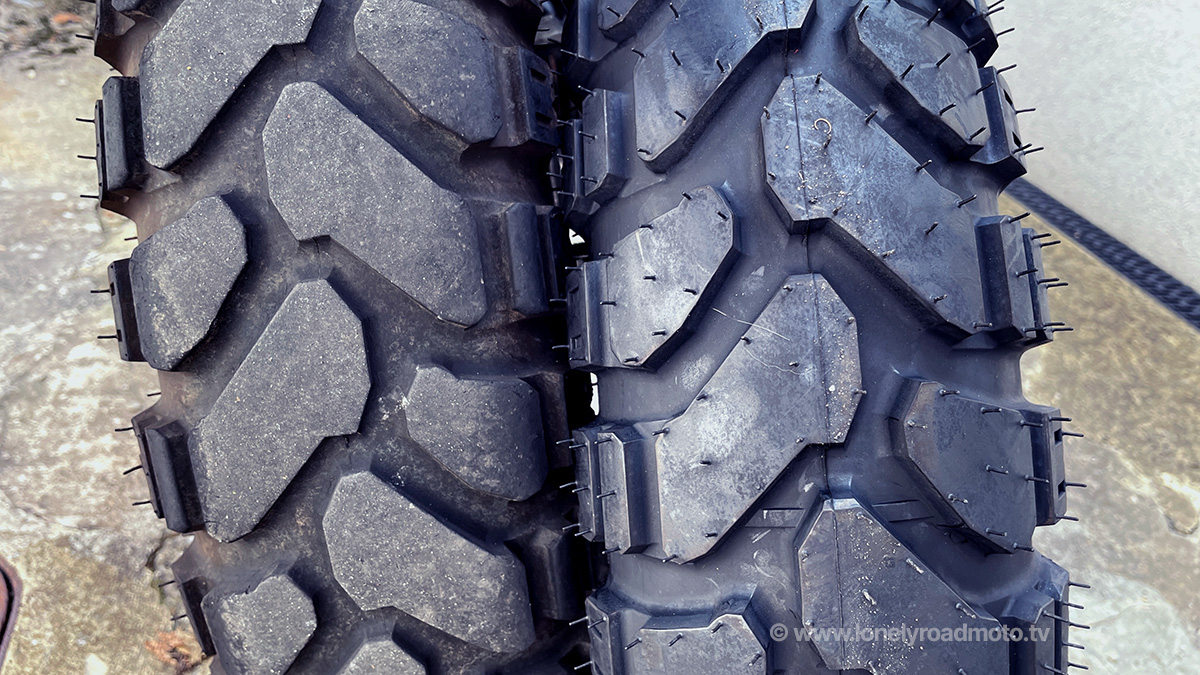 Close up of a worn Mitas e07+ rear tyre next to a new one