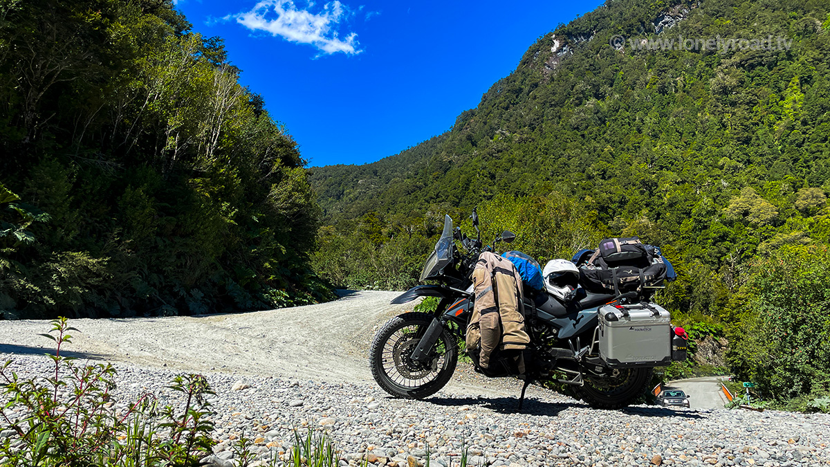 A KTM 890 Adventure motorcycle parked on a hairpin gravel road